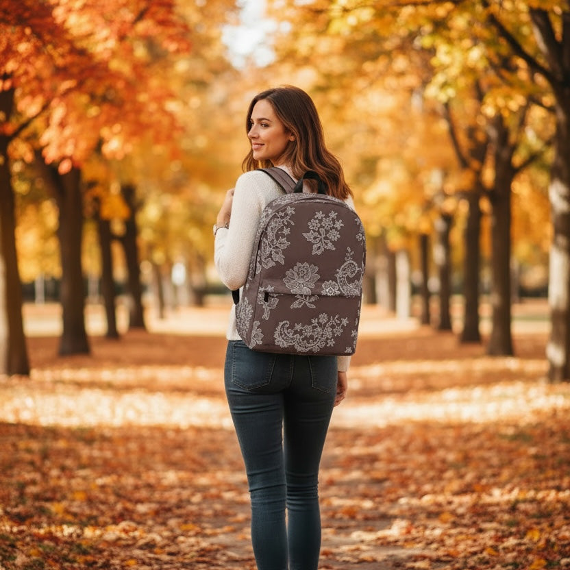Woman with a floral-patterned backpack walking through an autumnal park.