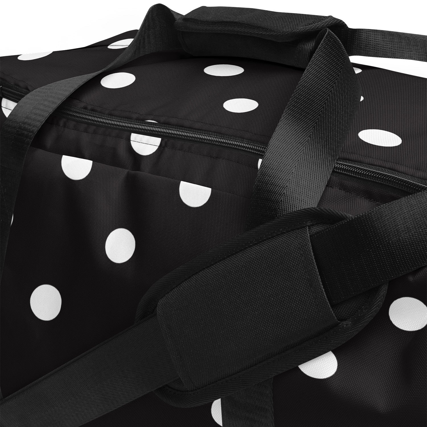 Black duffel bag with white polka dots and black straps on a white background