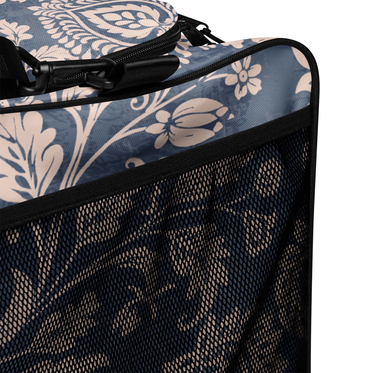 Close-up of a floral-patterned suitcase with a black mesh side panel.