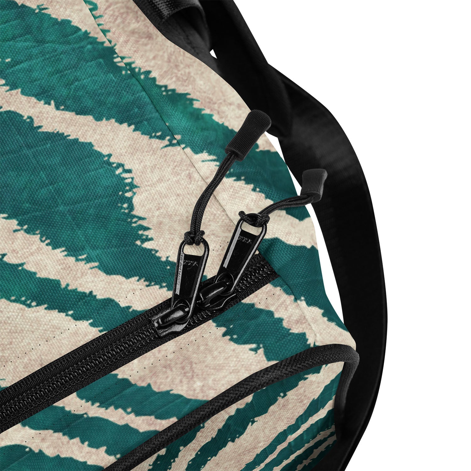 Close-up of a duffel with a green and beige pattern and black zipper.