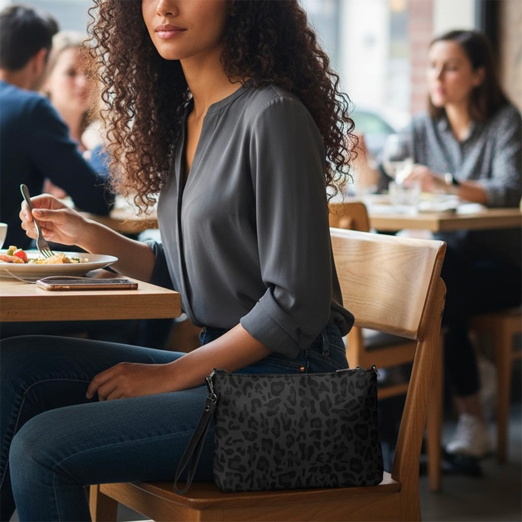Woman sitting at a restaurant table with a cheetah print crossbody bag