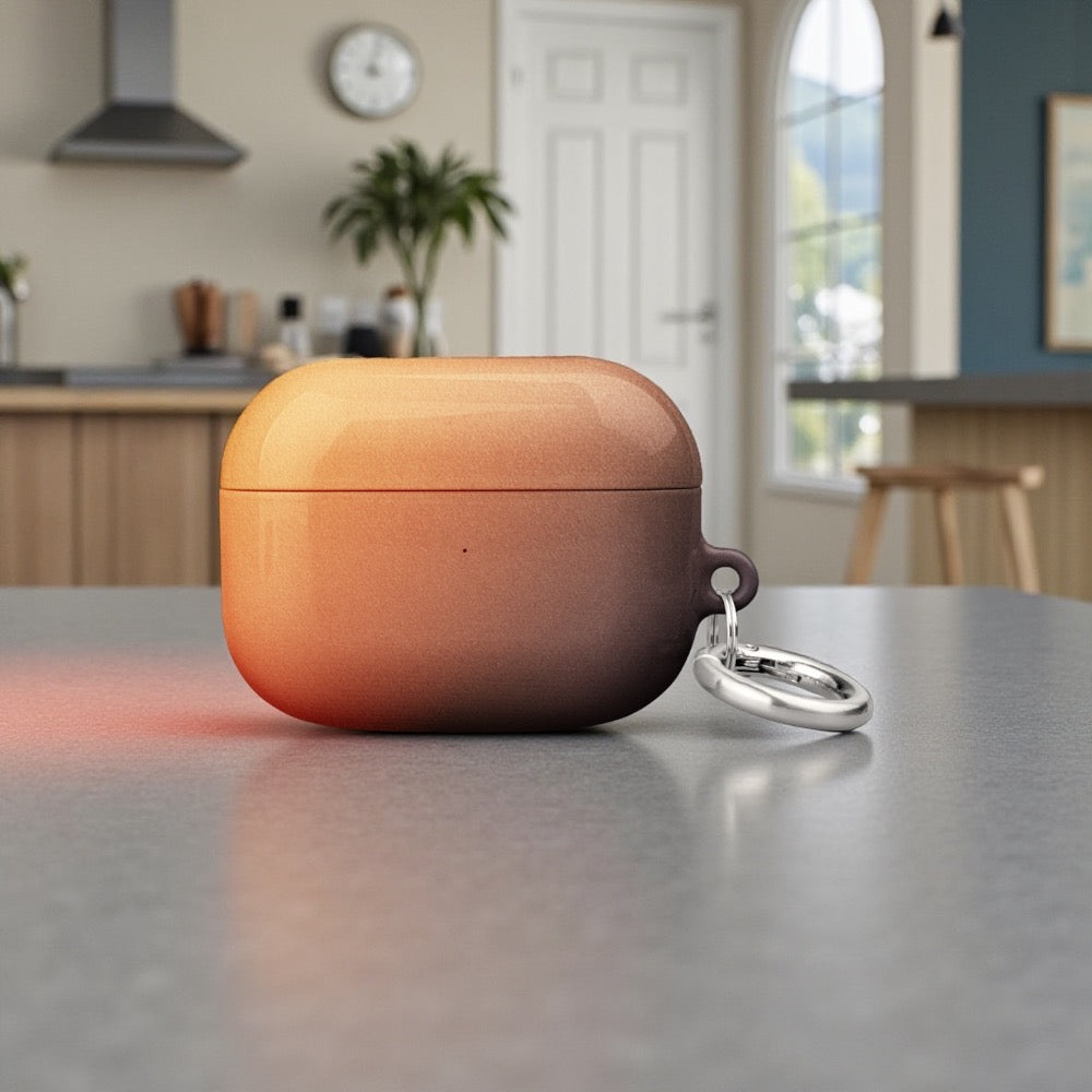 Orange wireless earbud case with keychain on a kitchen counter
