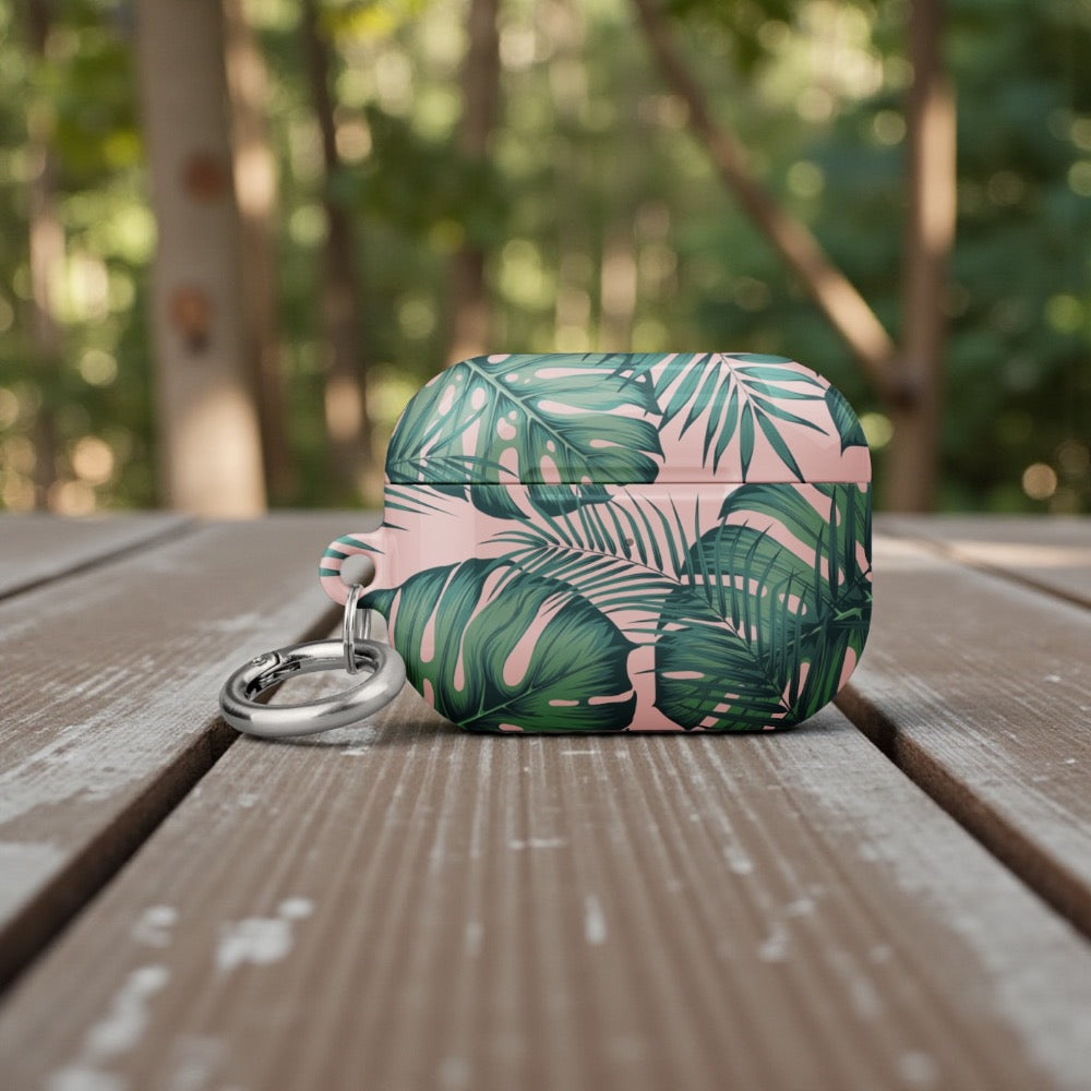 Green and pink leaf-patterned case on a wooden surface with a blurred natural background