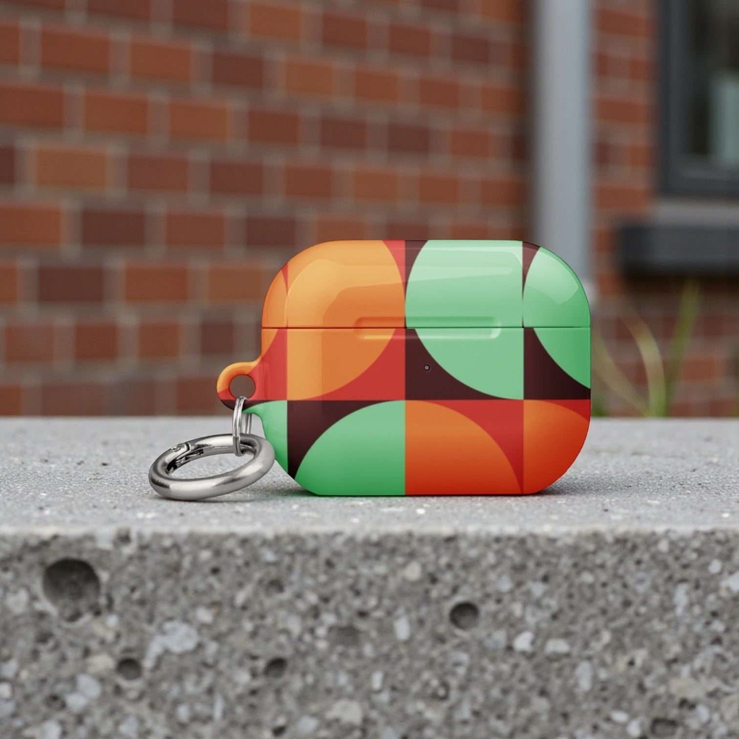 Colorful geometric keychain on a concrete surface with a brick wall background