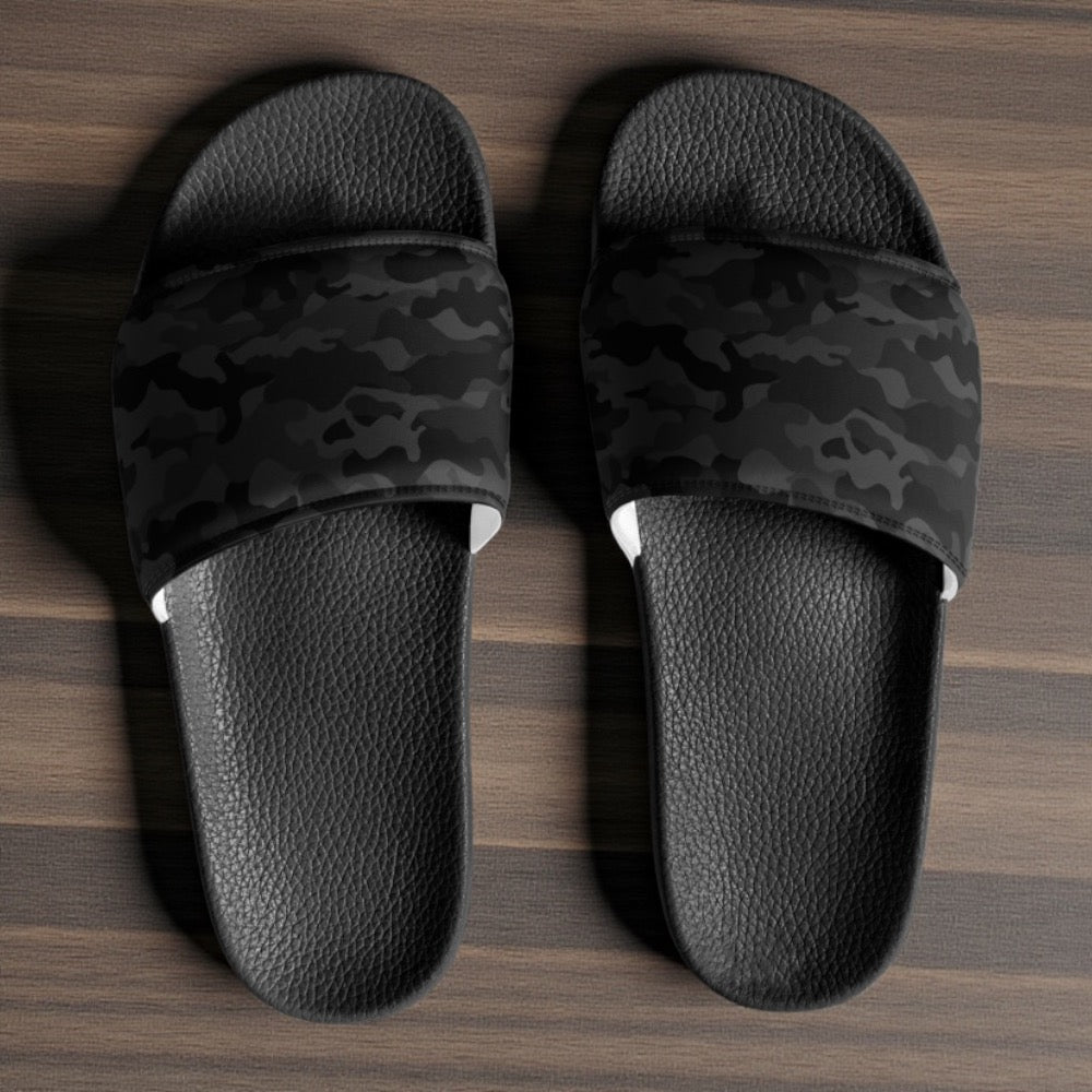 Black camouflage stealth slide sandals on a wooden floor
