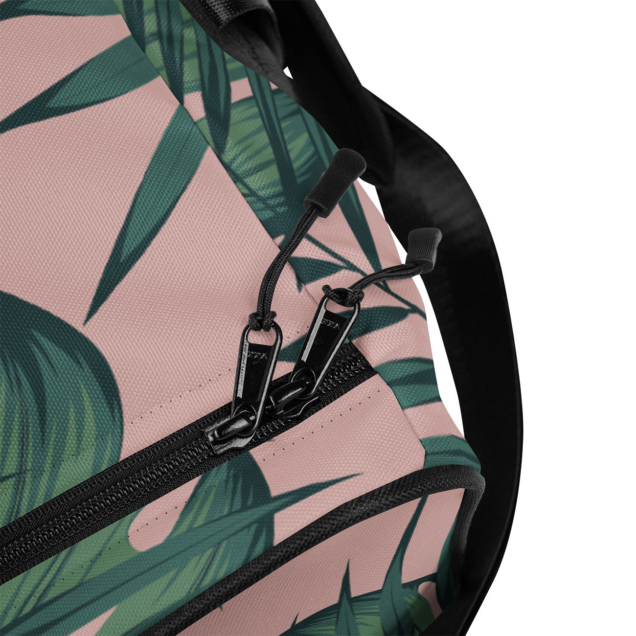Close-up of a backpack with black zipper and green leaf pattern on pink background