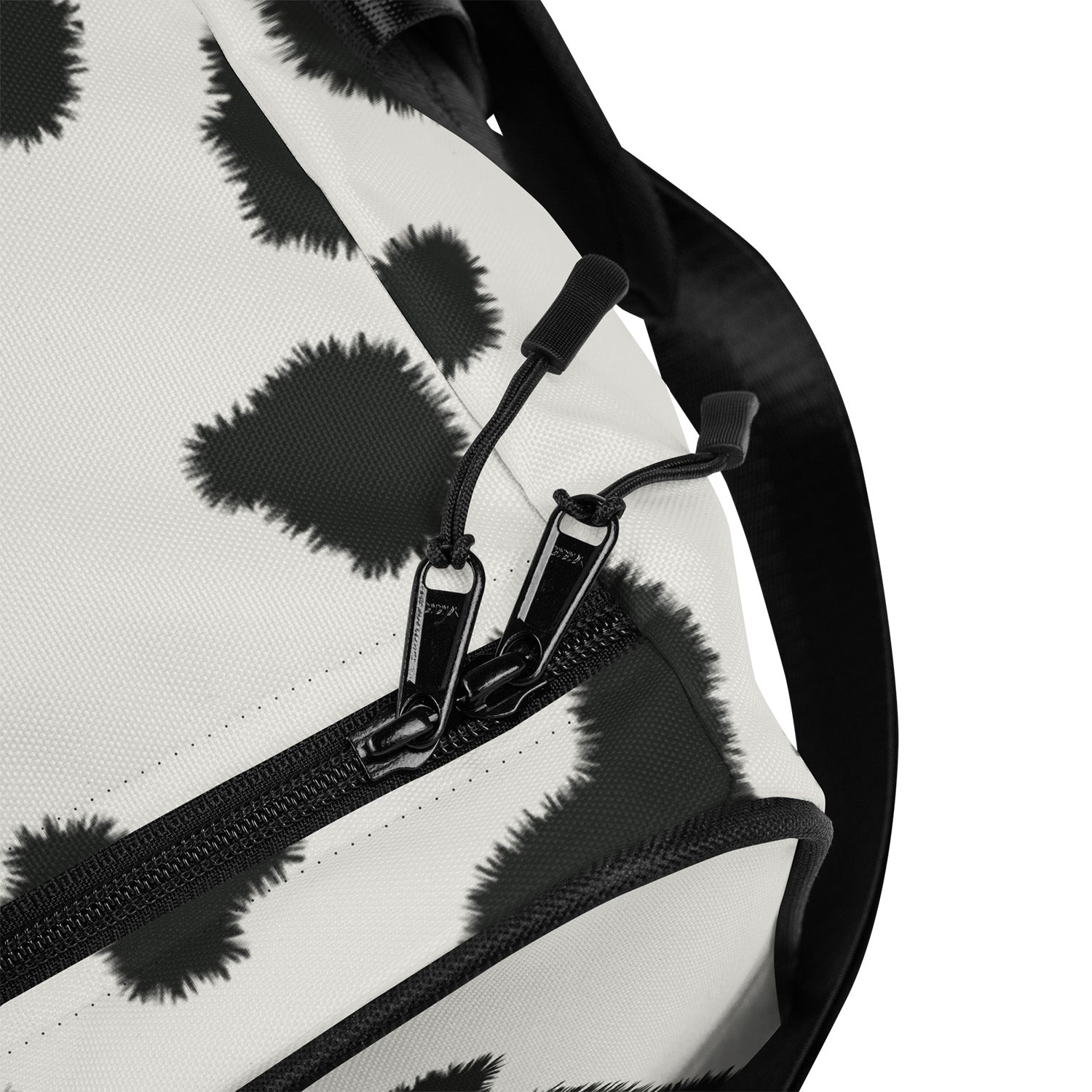Close-up of a bag with black floral pattern and zipper detail on a white background