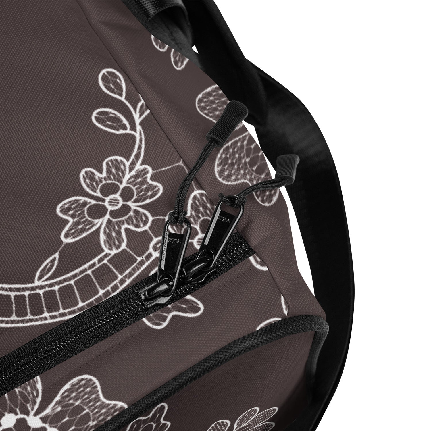 Close-up of a bag with floral patterns and zippers on a white background