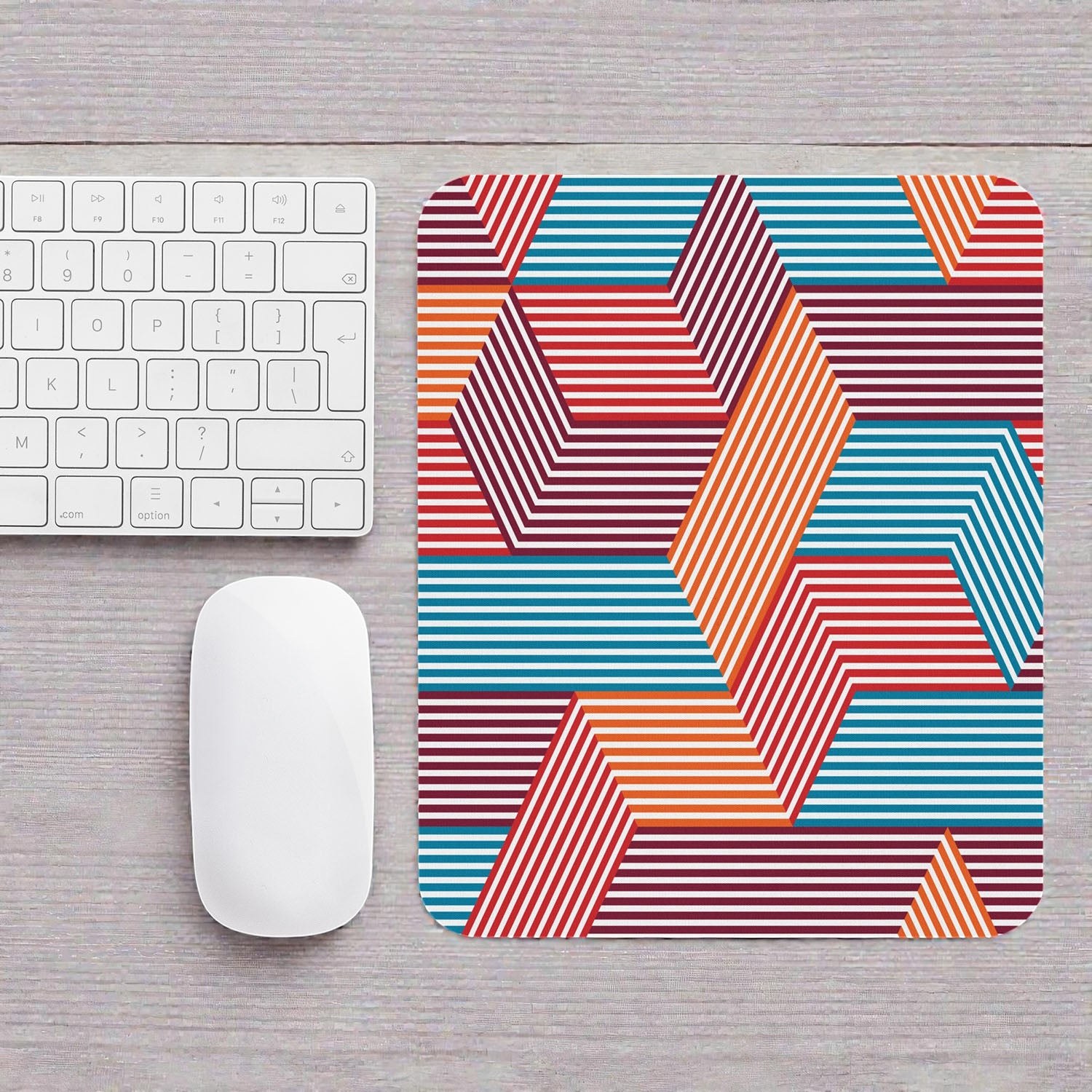Colorful geometric mouse pad on a desk with a keyboard and mouse.