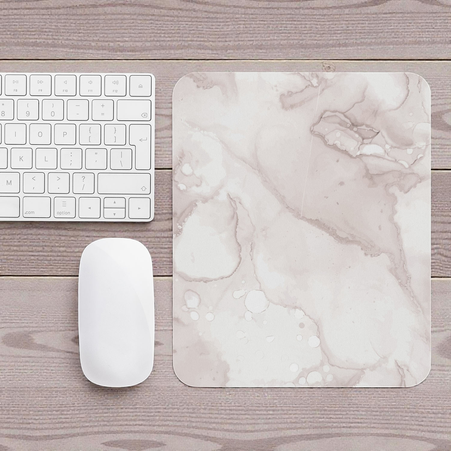 Marble-patterned mouse pad on a wooden desk with a keyboard and mouse.
