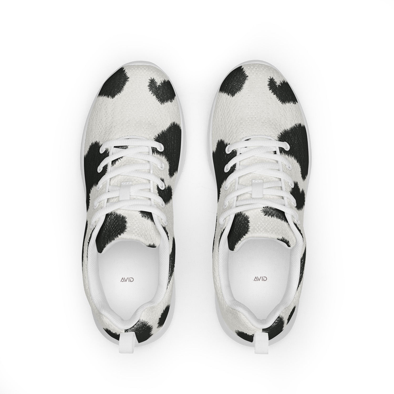 Pair of black and white cow print sneakers on a white background