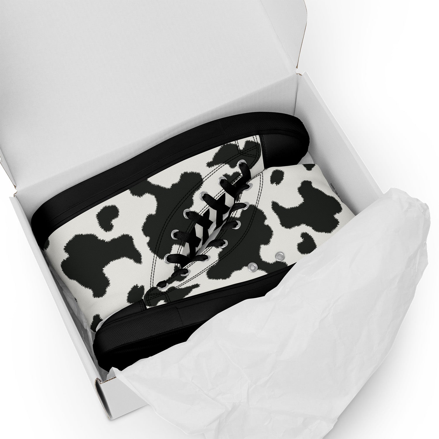 Black and white cow print sneaker in a white box on a white background