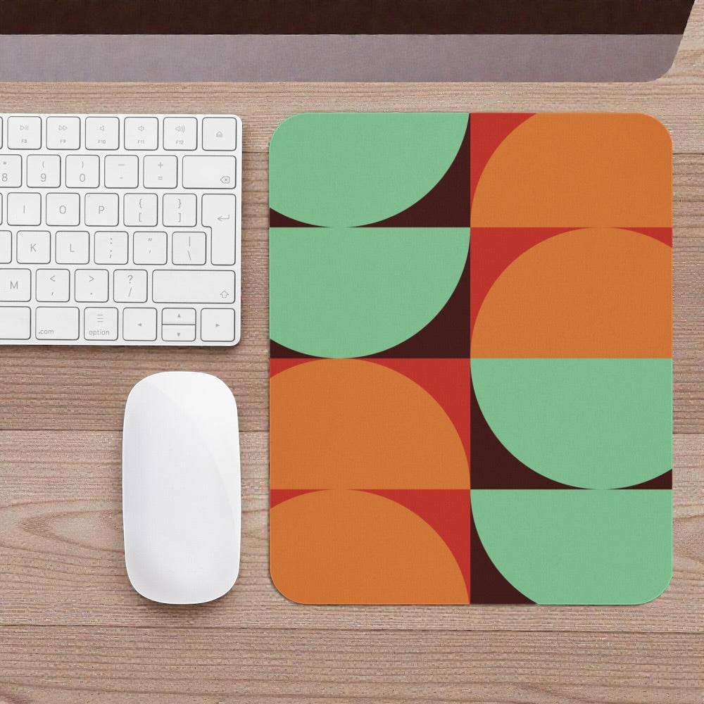 Colorful mouse pad with geometric design on a wooden desk with keyboard and mouse.